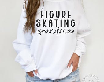 以下が含まれることがあります： 白いスウェットシャツに、黒い文字で「FIGURE SKATING grandma」と小さなハートが書かれています。
