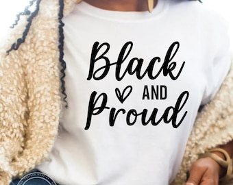 May include: A white t-shirt with the text "Black and Proud" in black cursive lettering with a heart symbol between the words.