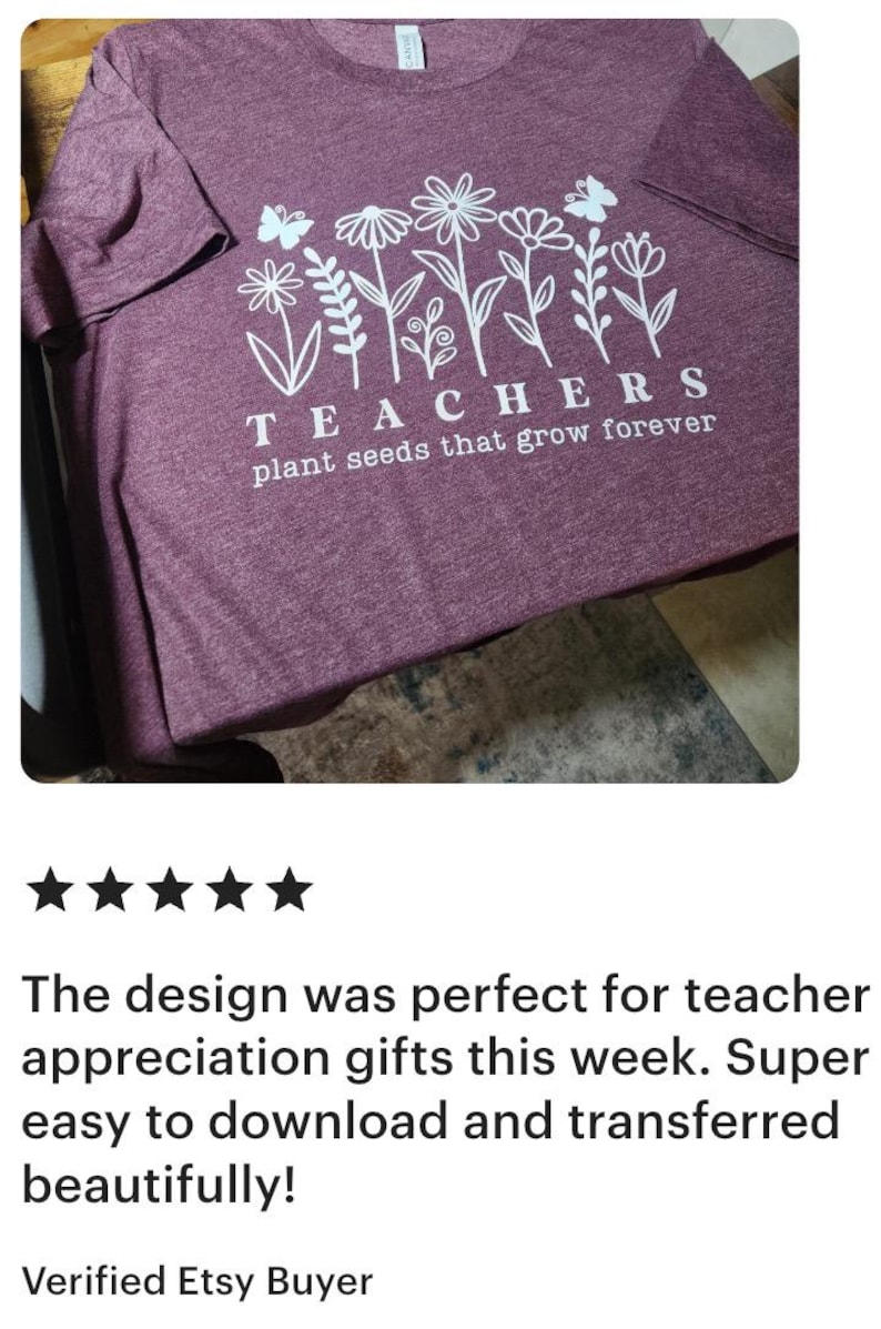 May include: Maroon t-shirt with a white floral design and the text "TEACHERS plant seeds that grow forever." The shirt has short sleeves and a crew neck. The design includes flowers and butterflies.