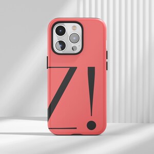 May include: A coral-colored phone case with a black graphic design featuring the letter "Z" and an exclamation point. The case has a glossy finish and a camera cutout. The phone case is designed to fit a smartphone.