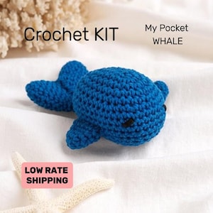 May include: Crochet kit for making a small blue whale. The kit includes yarn and instructions. "My Pocket WHALE" is written on the image.