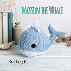 May include: A knitted blue whale toy with a white belly and accents. The whale has a black eye and a white spout. The text "Watson the Whale" is above the whale, and "Knitting Kit" is below.
