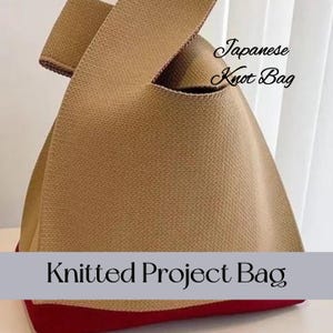 May include: A tan knitted project bag with a red bottom. The bag has a knotted handle and says "Japanese Knot Bag" and "Knitted Project Bag".
