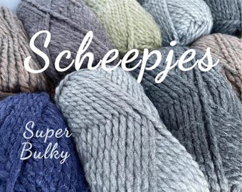 May include: Close-up of several skeins of super bulky yarn in various neutral colors, including gray, blue, and beige. The word "Scheepjes" is written across the top in white script, with "Super Bulky" below.