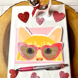 Chat avec des lunettes en forme de coeur