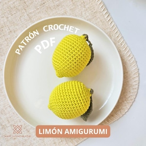 以下が含まれることがあります： 白い皿の上に、2つの黄色いレモンの編みぐるみが置かれています。レモンの周りに円形に「PATRÓN CROCHET PDF」という文字が書かれており、レモンの下に「LIMÓN AMIGURUMI」という文字が書かれています。