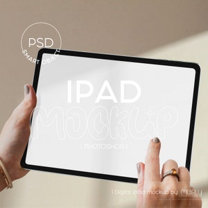 Puede incluir: Una maqueta de iPad blanca con el texto "IPAD MOCKUP | PHOTOSHOP |" en la pantalla. Una mano sostiene el iPad y un dedo apunta a la pantalla.