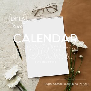 May include: A white DIN A size ratio calendar mockup with a spiral binding at the top, accompanied by a black pen, thin-rimmed glasses, and white flowers. The text DIN.A SIZE RATIO, CALENDAR MOCKUP, PHOTOSHOP, and Digital calendar mockup by Muply appear.