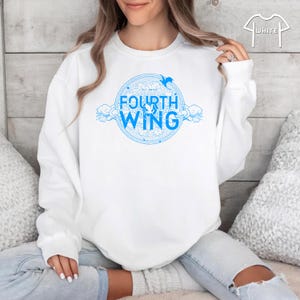 May include: White sweatshirt with a blue graphic design of a circle with the text "Fly On By" and "Fourth Wing" inside the circle. The graphic also includes a bird and clouds.