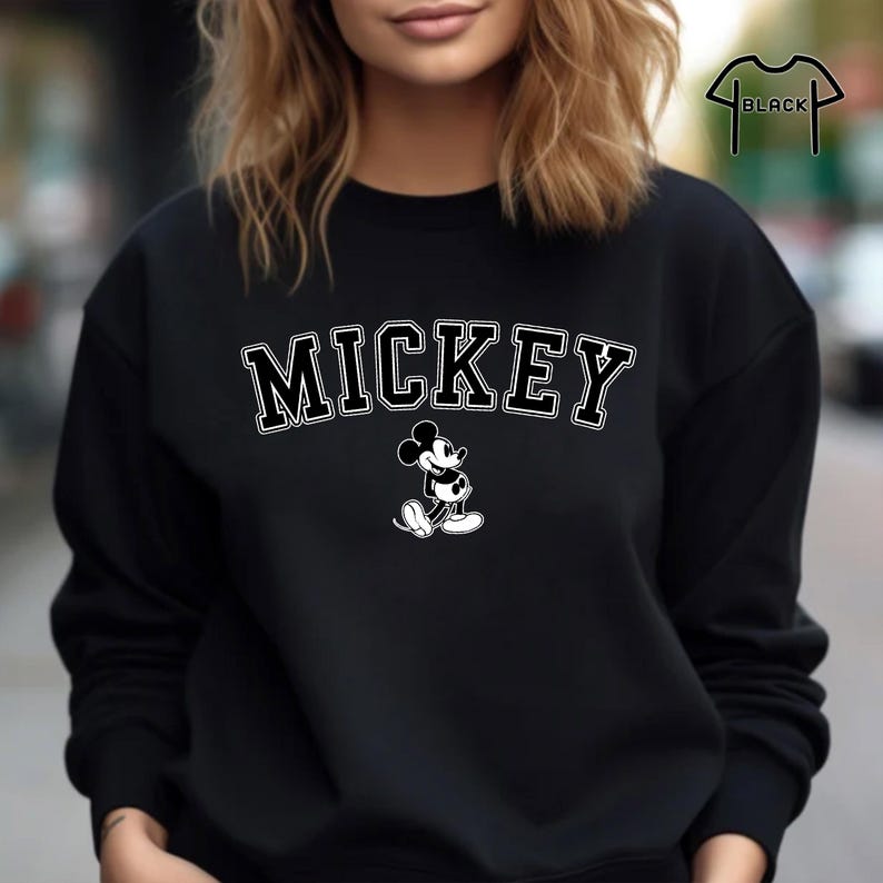 Puede incluir: Sudadera negra con un gr&aacute;fico de Mickey Mouse blanco y la palabra "MICKEY" en letras blancas.