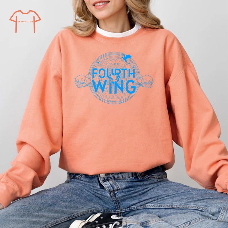 May include: A peach-colored sweatshirt with a blue graphic design that says "FOURTH WING" in a circle with a bird design above the text.