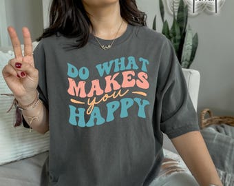 May include: A dark gray t-shirt with the text "Do What Makes You Happy" in a retro font with pink and blue accents.