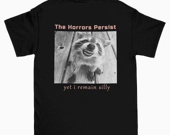 Los horrores persisten, pero sigo siendo tonto, camiseta gráfica divertida de mapache, camiseta de meme, camiseta de meme, camiseta de meme de mapache, camiseta gráfica divertida sarcástica