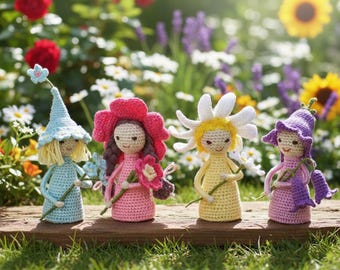 May include: Four handmade crochet dolls, each resembling a flower fairy, stand on a wooden surface. The dolls are in shades of blue, pink, yellow, and purple, holding flowers. The background features a vibrant garden with flowers and greenery.