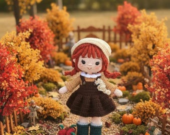 May include: A handcrafted crochet doll with reddish-brown yarn hair, wearing a cream-colored beret, a tan long-sleeved top, a dark brown pinafore dress, and dark green boots. The doll holds a small white floral accent and stands near a basket of red apples.