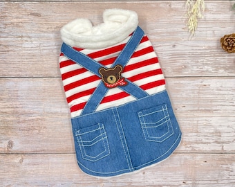 May include: Red and white striped dog sweater with blue denim overalls and a brown bear applique. The overalls have two front pockets.