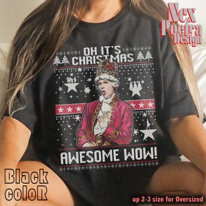 Peut inclure: T-shirt noir avec un motif festif représentant un personnage historique en manteau rouge et couronne. Le texte "OH IT'S CHRISTMAS AWESOME WOW!" est affiché dans un style pull de Noël avec des flocons de neige et des étoiles.