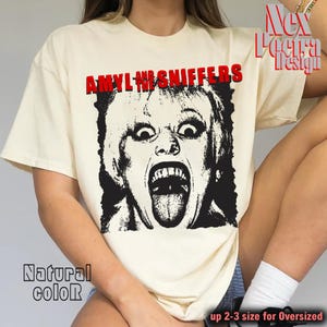 Puede incluir: Camiseta color crema con un gráfico en blanco y negro de una cara gritando y el texto rojo "AMYL AND THE SNIFFERS". La camiseta también tiene el texto "Natural color" y "up 2-3 size for Oversized".