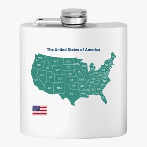 Könnte beinhalten: Eine weiße Edelstahl-Trinkflasche mit einer Karte der Vereinigten Staaten von Amerika auf der Vorderseite. Die Karte ist in blaugrün gehalten und zeigt die Staatsgrenzen. Die Flasche hat einen silbernen Verschluss und einen silbernen Griff. Der Text "The United States of America" ist in Blau oben auf der Karte gedruckt. Eine kleine amerikanische Flagge ist in der linken unteren Ecke der Flasche gedruckt.
