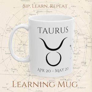 May include: White ceramic mug with the Taurus zodiac sign. The mug displays the word "TAURUS" in black, the Taurus symbol, and the dates "APR 20 - MAY 20". The mug also has the text "SIP, LEARN, REPEAT" and "LEARNING MUG".