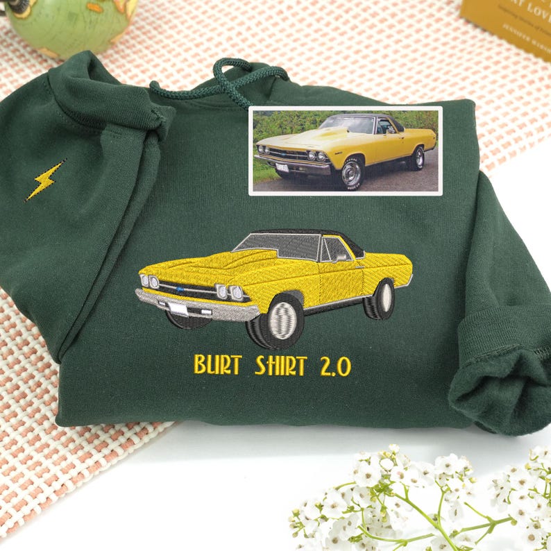 Forest green embroidered sweatshirt with yellow vintage car design, personalized text “Burt Shirt 2.0,” and lightning bolt detail on sleeve. Custom car embroidery gift for car enthusiasts and collectors.