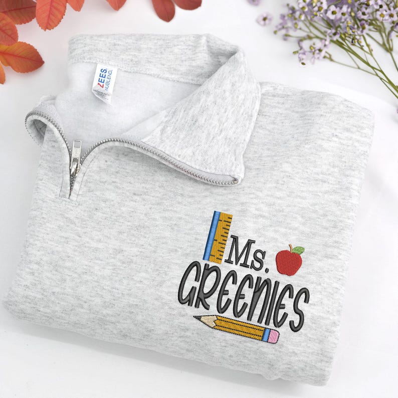 Custom embroidered ash quarter-zip sweatshirt with “Ms. Greenies” and cute apple, pencil, and ruler design — personalized teacher sweatshirt, thoughtful back-to-school gift, teacher appreciation present, or cozy classroom wear.