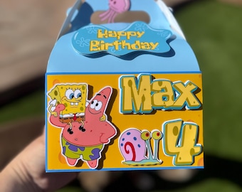 May include: A blue and yellow party favor box with a SpongeBob SquarePants and Patrick Star cartoon character design. The box has a handle and says "Happy Birthday Max 4" on the front.