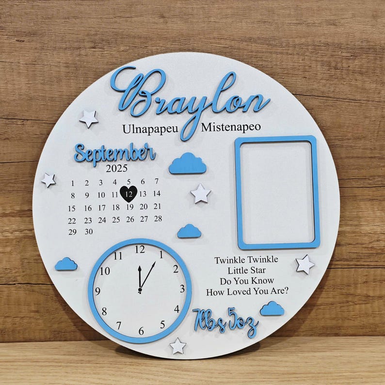 May include: A white and blue wooden baby announcement sign. The sign includes the name "Braylon", a calendar for September 2025, a clock, a photo frame, and the text "Twinkle Twinkle Little Star". The sign also includes the baby's weight.