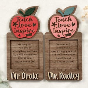 Puede incluir: Dos placas enmarcadas de madera con un diseño de manzana roja. La manzana tiene las palabras "Teach *Love Inspire". Las placas tienen un poema que dice "We may not remember everything you said but we'll remember how special you make us feel". Las placas tienen los nombres "Mr Drake" y "Mr Radley" en la parte inferior.
