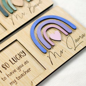 May include: Wooden sign with a rainbow design and the text "I SO LUCKY to have you as my teacher" and "Mrs. Laura".