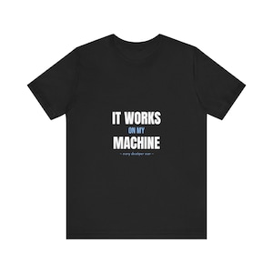 May include: A black short-sleeved t-shirt featuring the white text IT WORKS ON MY MACHINE with the word ON MY in light blue and the smaller text - every developer ever - in light blue centered on the chest area of the garment.