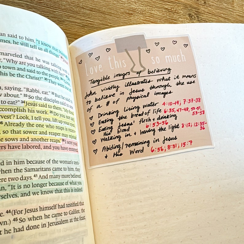 May include: A beige sticky note with the text "Love this so much" written in black marker. The note lists tangible images of believing in Jesus, including drinking living water, eating the bread of life, eating Jesus' flesh and drinking his blood, walking in having the light, and abiding/remaining in Jesus. The note includes Bible verses in red.