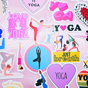 Op de afbeelding: Assortiment van kleurrijke stickers met yoga-thema's. De stickers bevatten afbeeldingen van mensen die yoga-houdingen doen, harten en de woorden "Love Yoga", "Just Breath" en "Yoga".