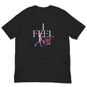May include: A black t-shirt with the text "I FEEL love" printed in white. The word "love" is written in a stylized script with a pink and blue watercolor effect.