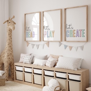 May include: A wooden storage bench with six white bins, decorated with three framed prints that say "Let's Read", "Let's Play", and "Let's Create". The prints have rainbow coloured letters. A woven giraffe figurine stands next to the bench.
