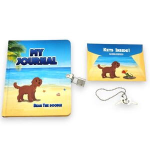 May include: A blue and yellow journal with a beach scene and a brown dog on the cover. The journal has a lock and key and says "My Journal" and "Bear the Doodle" on the cover. The journal comes with a separate card that says "Keys Inside!" and a key chain with two keys.