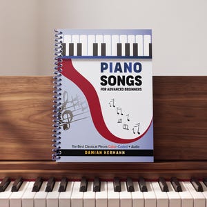 May include: A spiral-bound music book titled Piano Songs for Advanced Beginners by Damian Hermann. The cover features a piano keyboard graphic, a red curved shape, musical notes, and the text The Best Classical Pieces Color-Coded + Audio.