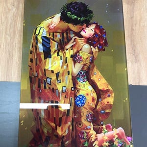 May include: A colourful painting of a couple embracing in a field of flowers. The painting is done in a style reminiscent of Gustav Klimt's "The Kiss" with a mosaic-like pattern of gold, yellow, and blue.