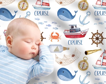 May include: A sleeping baby in a blue and white striped top, set against a nautical-themed pattern. The pattern features sailboats, whales, anchors, compasses, and the word "CRUISE".