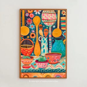 May include: A framed, colorful kitchen-themed art print. The artwork features various kitchen utensils, bowls, and a vase, all in vibrant colors like orange, blue, and pink. The background is a dark blue with floral patterns. The overall style is whimsical and decorative.