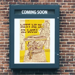 May include: A teal-framed poster on a brick wall announces "COMING SOON." The poster features a yellow and white illustration with the text "MEET ME IN ST. LOUIS." The image depicts a trolley car with passengers and buildings.