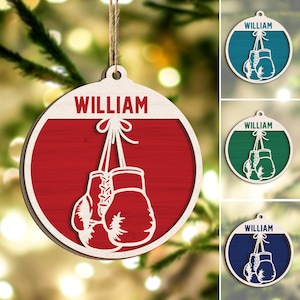 May include: A red, white, and blue Christmas ornament with the name "William" and a pair of boxing gloves hanging from a string.