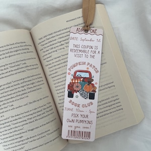 May include: A rectangular paper bookmark with a tan ribbon, featuring the text ADMIT ONE, DATE: September 1st, THIS COUPON IS REDEEMABLE FOR A VISIT TO THE PUMPKIN PATCH, BOOK CLUB, TIME: 10am - 5pm, PICK YOUR OWN PUMPKINS, see you soon!, and a barcode.