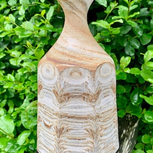 Könnte beinhalten: Eine weiße und braune Keramikvase mit einem wirbelnden Muster. Die Vase hat einen schmalen Hals und einen breiten Boden.