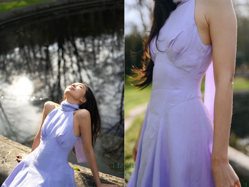 May include: A pale purple halter-neck dress with a flared skirt. The dress has a high neckline and a fitted bodice. The model is outside, with sunlight highlighting the dress. The dress is made of a soft, flowing material.