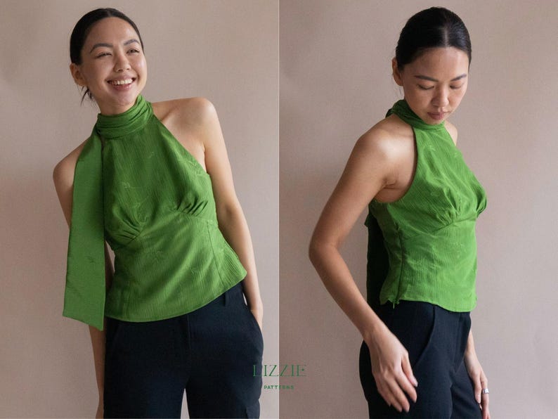 May include: A green halterneck top with a high neckline and a flowing sash detail. The top has a fitted bodice and is paired with black trousers. The image shows the top from multiple angles.
