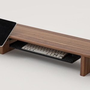 K&ouml;nnte beinhalten: Ein Laptop-St&auml;nder aus Holz mit einem ausziehbaren Tastaturablage und einem Tablethalter. Der St&auml;nder ist aus dunklem Holz und hat ein modernes Design.