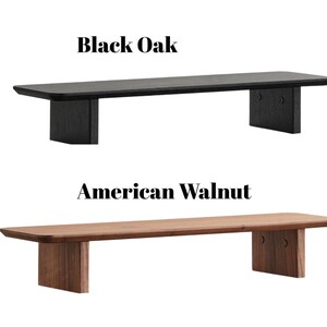 May include: Two low wooden benches are displayed. The top bench is black oak, and the bottom bench is American walnut. Each bench has a rectangular top and two supporting legs. The text "Black Oak" and "American Walnut" are above the benches.