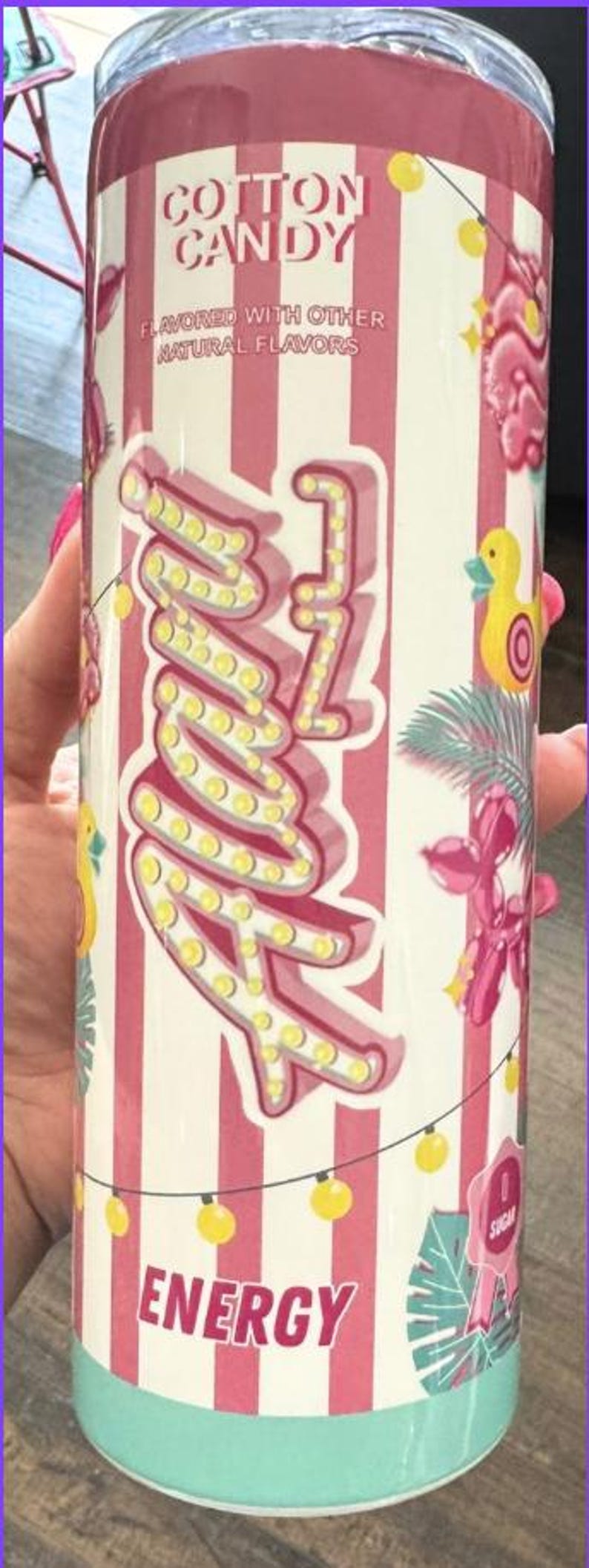 Puede incluir: Un vaso con tem&aacute;tica de algod&oacute;n de az&uacute;car con un fondo a rayas rosas y blancas. El vaso presenta las palabras "Cotton Candy" y "Energy" en una fuente l&uacute;dica, junto con un dise&ntilde;o "Zzz" y elementos decorativos.