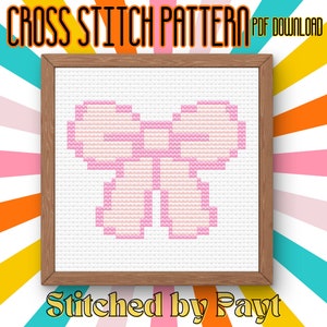 Könnte beinhalten: Ein Kreuzstichmuster mit einem rosa Schleifendesign, eingerahmt in einem Holzrahmen. Der Text "CROSS STITCH PATTERN PDF DOWNLOAD" steht oben und "Stitched by Payt" unten, vor einem farbenfrohen gestreiften Hintergrund.